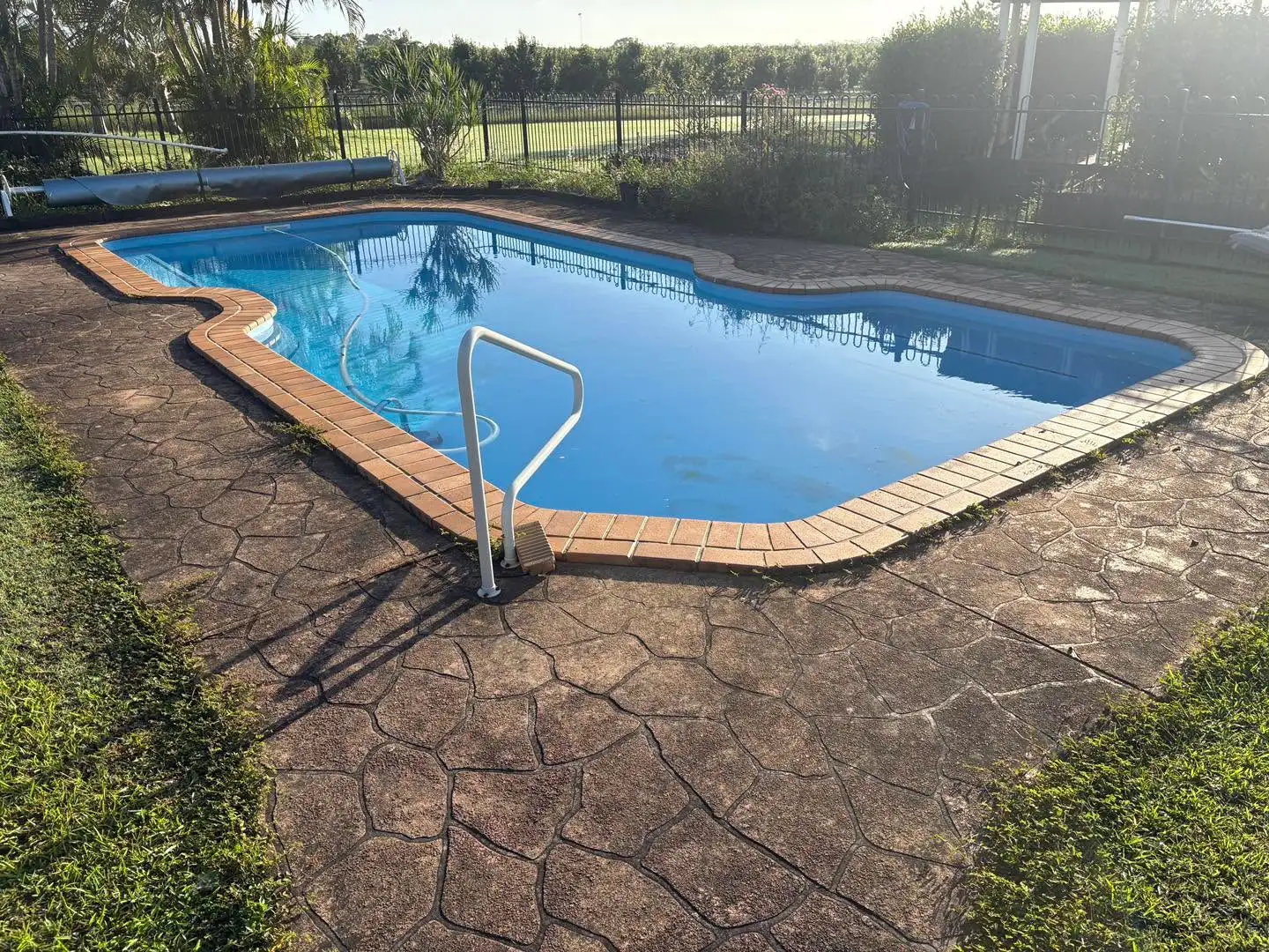 Weathered pool pavers before pressure washing